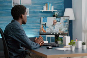 A patient is sitting at his desk speaking virtually with a physician. He is feeling more confident in his decision after an online second opinion.