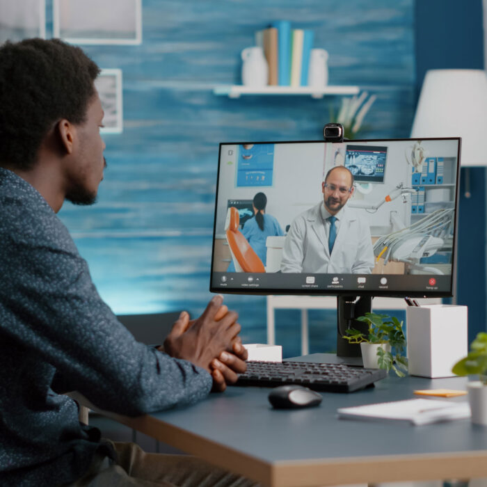 A patient is sitting at his desk speaking virtually with a physician. He is feeling more confident in his decision after an online second opinion.