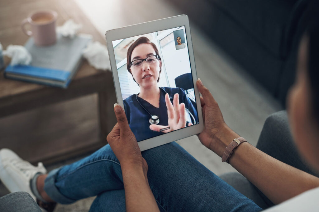 A person is holding their tablet and speaking with a physician about their remote second opinion.