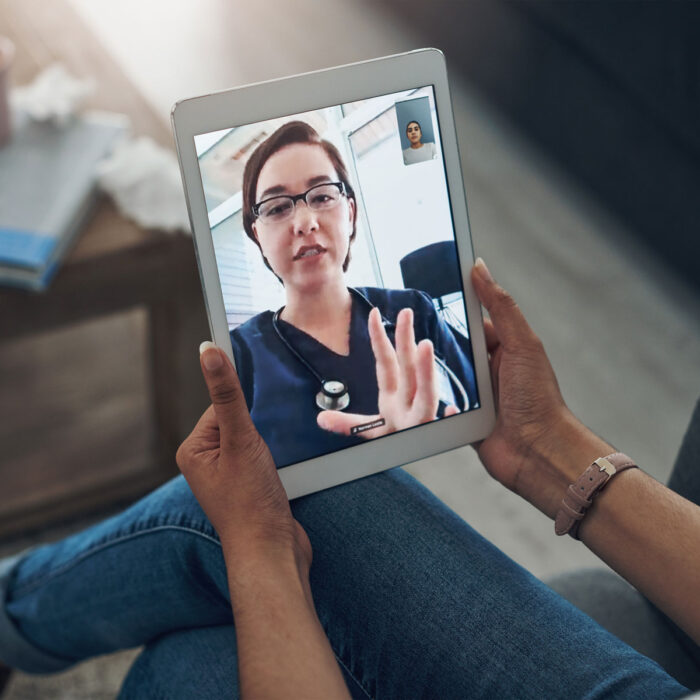 A person is holding their tablet and speaking with a physician about their remote second opinion.